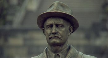 Movie still from “Underground” (1995), directed by Emir Kusturica – A statue of a man wearing a hat; Close Up shot, Low angle