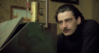 Movie still from “Underground” (1995), directed by Emir Kusturica – A man with glasses is looking at a faucet; Close Up shot, High angle