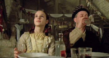 Movie still from “Underground” (1995), directed by Emir Kusturica – A man and a woman sitting at a table; Medium shot, Low angle