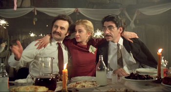 Movie still from “Underground” (1995), directed by Emir Kusturica – A group of people sitting at a dinner table; Medium shot, Low angle