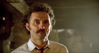 Movie still from “Underground” (1995), directed by Emir Kusturica – A person wearing a shirt and a tie; Close Up shot, Low angle