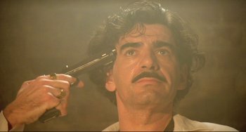 Movie still from “Underground” (1995), directed by Emir Kusturica – A person cutting his hair; Close Up shot, Low angle