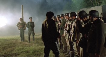 Movie still from “Underground” (1995), directed by Emir Kusturica – A group of men standing next to each other in a field; Wide shot, Low angle