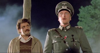 Movie still from “Underground” (1995), directed by Emir Kusturica – A man in a military uniform stands next to another man; Medium shot, Low angle