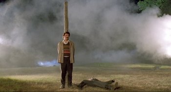 Movie still from “Underground” (1995), directed by Emir Kusturica – A man standing next to a dead body in a field; Wide shot, Low angle