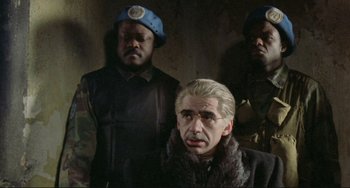 Movie still from “Underground” (1995), directed by Emir Kusturica – A group of men standing next to each other in a room; Medium shot, Over the shoulder angle