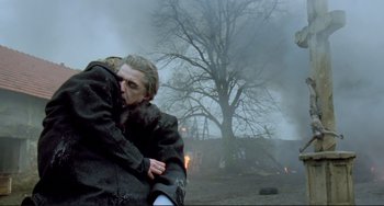 Movie still from “Underground” (1995), directed by Emir Kusturica – A man and a woman hugging in front of a burning tree; Medium shot, Low angle