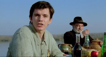 Movie still from “Underground” (1995), directed by Emir Kusturica – A man sitting next to another man at a table; Close Up shot, Low angle