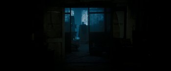 Movie still from “Underworld: Awakening” (2012), directed by Björn Stein – A person is sitting in a dark room; Extreme Wide shot, Over the shoulder angle