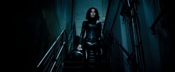 Movie still from “Underworld: Awakening” (2012), directed by Björn Stein – A woman in a black outfit walking down a flight of stairs; Wide shot, Low angle