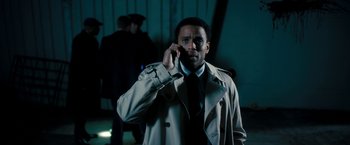 Movie still from “Underworld: Awakening” (2012), directed by Björn Stein – A man in a trench coat talking on a cell phone; Medium shot, Over the shoulder angle