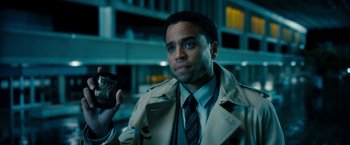 Movie still from “Underworld: Awakening” (2012), directed by Björn Stein – A man in a trenchcoat and tie holding a cell phone; Close Up shot, Over the shoulder angle