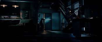 Movie still from “Underworld: Awakening” (2012), directed by Björn Stein – A woman standing in a dark room next to a door; Extreme Wide shot, High angle
