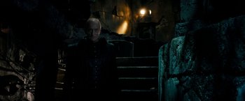 Movie still from “Underworld: Awakening” (2012), directed by Björn Stein – An old man standing next to some steps in the dark; Medium shot, Low angle