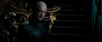 Movie still from “Underworld: Awakening” (2012), directed by Björn Stein – An old man with a bald head standing in front of some stairs; Close Up shot, Low angle