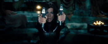 Movie still from “Underworld: Awakening” (2012), directed by Björn Stein – A woman in a catsuit holding two guns in her hands; Medium shot, Over the shoulder angle