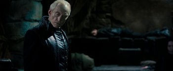 Movie still from “Underworld: Awakening” (2012), directed by Björn Stein – An older man standing in front of a man laying on the ground; Close Up shot, Over the shoulder angle