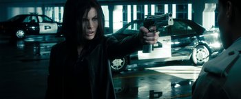Movie still from “Underworld: Awakening” (2012), directed by Björn Stein – A woman holding a gun in her hand; Medium shot, Low angle