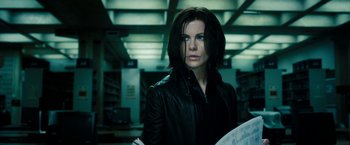 Movie still from “Underworld: Awakening” (2012), directed by Björn Stein – A woman in a black leather jacket holding a map; Medium shot, Low angle