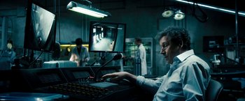 Movie still from “Underworld: Awakening” (2012), directed by Björn Stein – A man sitting in front of a computer monitor; Medium shot, Over the shoulder angle