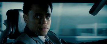 Movie still from “Underworld: Awakening” (2012), directed by Björn Stein – A person wearing a suit in a car; Close Up shot, Over the shoulder angle