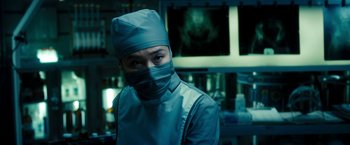 Movie still from “Underworld: Awakening” (2012), directed by Björn Stein – A person wearing a surgical mask and a surgical gown; Medium shot, Low angle