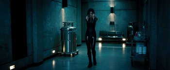 Movie still from “Underworld: Awakening” (2012), directed by Björn Stein – A woman in a black outfit is holding a gun; Wide shot, Low angle