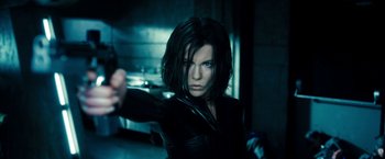 Movie still from “Underworld: Awakening” (2012), directed by Björn Stein – A person holding a gun in a room; Close Up shot, Low angle