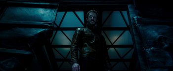 Movie still from “Underworld: Awakening” (2012), directed by Björn Stein – A man in a leather jacket standing in a dark room; Medium shot, Low angle