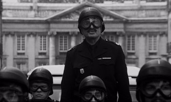 Movie still from “A Room in Town” (1982), directed by Jacques Demy – An old man in a military uniform with two young boys; Medium shot, Low angle