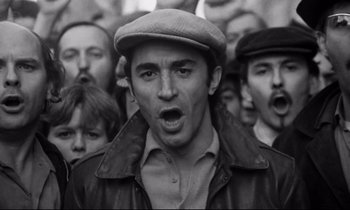 Movie still from “A Room in Town” (1982), directed by Jacques Demy – Black and white photograph of a crowd of people; Close Up shot, High angle