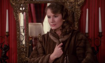Movie still from “A Room in Town” (1982), directed by Jacques Demy – A woman wearing a fur coat in front of a mirror; Close Up shot, Over the shoulder angle