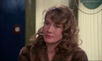 Movie still from “A Room in Town” (1982), directed by Jacques Demy – A woman in a fur coat looking at the camera; Close Up shot, Over the shoulder angle