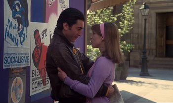 Movie still from “A Room in Town” (1982), directed by Jacques Demy – A man and a woman embracing each other outside; Medium shot, Low angle