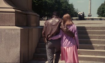 Movie still from “A Room in Town” (1982), directed by Jacques Demy – A man and a woman are walking down the stairs; Wide shot, High angle