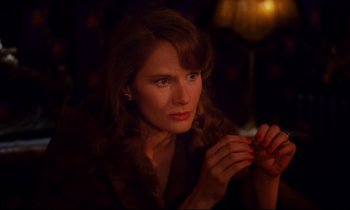 Movie still from “A Room in Town” (1982), directed by Jacques Demy – A woman is holding a cigarette in her hand; Close Up shot, High angle