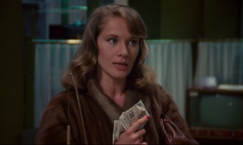 Movie still from “A Room in Town” (1982), directed by Jacques Demy – A woman in a fur coat holding a purse; Close Up shot, Over the shoulder angle