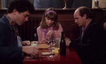 Movie still from “A Room in Town” (1982), directed by Jacques Demy – Three people sitting at a table in a restaurant; Medium shot, Over the shoulder angle