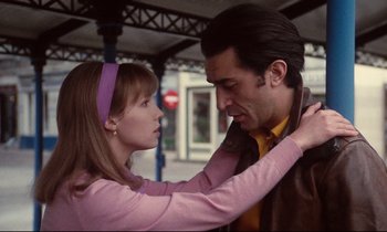 Movie still from “A Room in Town” (1982), directed by Jacques Demy – A man and a woman touching each other's neck; Medium shot, Low angle
