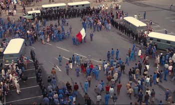 Movie still from “A Room in Town” (1982), directed by Jacques Demy – An aerial view of a crowd of people in blue uniforms; Extreme Wide shot, High angle