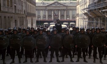 Movie still from “A Room in Town” (1982), directed by Jacques Demy – A large group of men in black uniforms and helmets; Extreme Wide shot, High angle