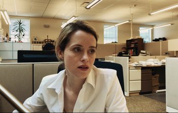 Movie still from “Unsane” (2018), directed by Steven Soderbergh – A woman sitting in an office chair in a cubicle; Close Up shot, Over the shoulder angle