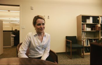Movie still from “Unsane” (2018), directed by Steven Soderbergh – A woman sitting at a table in an office setting; Medium shot, Over the shoulder angle