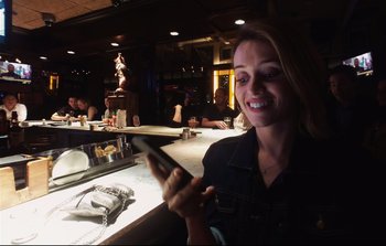 Movie still from “Unsane” (2018), directed by Steven Soderbergh – A woman sitting at a table in front of a phone; Medium shot, Low angle