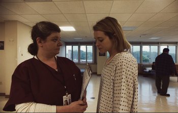 Movie still from “Unsane” (2018), directed by Steven Soderbergh – Two women are talking in an office setting; Medium shot, Over the shoulder angle