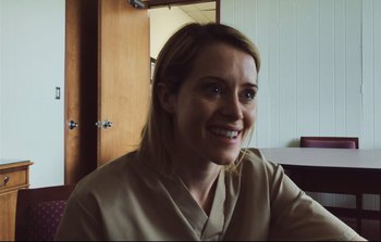 Movie still from “Unsane” (2018), directed by Steven Soderbergh – A woman smiles for the camera while sitting at a table; Close Up shot, Over the shoulder angle