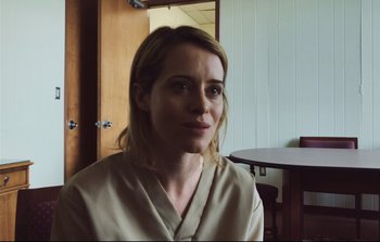 Movie still from “Unsane” (2018), directed by Steven Soderbergh – A woman sitting in front of a wooden table; Close Up shot, Over the shoulder angle