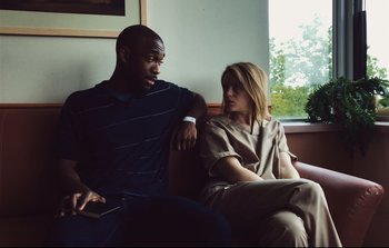 Movie still from “Unsane” (2018), directed by Steven Soderbergh – A man and a woman sitting next to each other on a couch; Medium shot, Over the shoulder angle