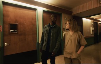 Movie still from “Unsane” (2018), directed by Steven Soderbergh – A man and a woman standing next to each other in a room; Medium shot, Low angle