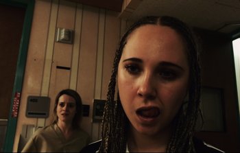 Movie still from “Unsane” (2018), directed by Steven Soderbergh – Two women in a room with a wall behind them; Close Up shot, Over the shoulder angle